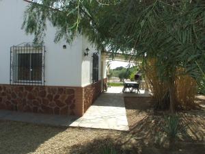 a house with a tree in front of it at Finca Arboleda in Vera