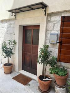 two potted trees sitting in front of a door at Old Town Stay by Ivo in Trogir