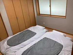 1 cama no hecha en un dormitorio con ventana en 寺田旅館一軒家レンタル素泊まり最大15人宿泊可能 4名様まで同一料金, en Mine