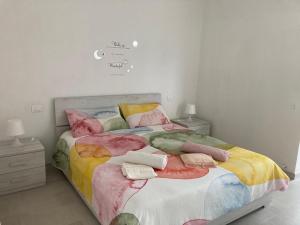 a bedroom with a bed with colorful blankets and pillows at Massa Love Stay in Massa Marittima