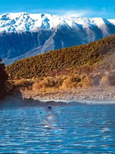 a person in the water in front of a mountain at Joan Guesthouse in Përmet