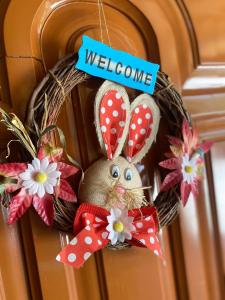 a wreath with a bunny on a door with a welcome sign at Joan Guesthouse in Përmet