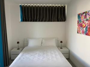 a bedroom with a white bed with two night stands at Sirmio Apartments - Darsena Stay in Sirmione
