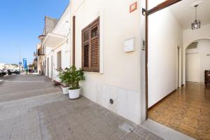 an empty street with potted plants on the side of a building at A casa di nonna Vincenza in San Vito lo Capo