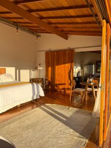 a bedroom with a bed and a table and chairs at Cabana Girassol com piscina aquecida e cesta para café da manhã in Gonçalves +23 photos