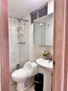 a white bathroom with a toilet and a sink at MIRADOR DE CASTILLA - Sector CENTRAL in Manizales +17 photos
