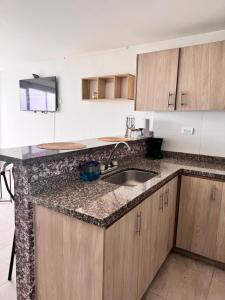 a kitchen with wooden cabinets and a sink at MIRADOR DE CASTILLA - Sector CENTRAL in Manizales