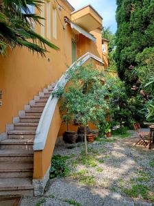 schody prowadzące do budynku z drzewem w obiekcie Casa Lucy w mieście Bardolino