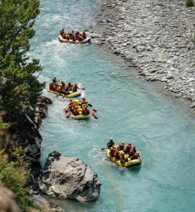 a group of people in boats on a river at Joan Guesthouse in Përmet