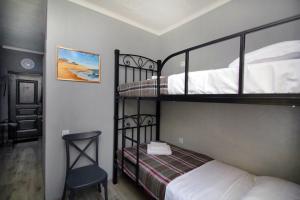 a bedroom with two bunk beds and a chair at KazNest apart-hotel in Almaty