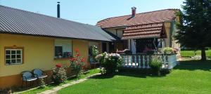 a yellow house with flowers on the front yard at Dobrodošli in Mursko Središće