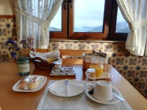 a table with plates of food and drinks on it at Fragas da Canteira Hotel Rural in Lires