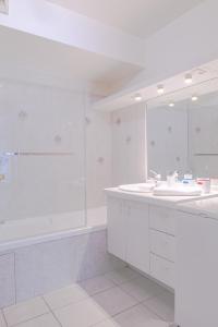 une salle de bain blanche avec une baignoire et un lavabo dans l'établissement Le Gouverneur, 100m du lac avec parking, à Annecy