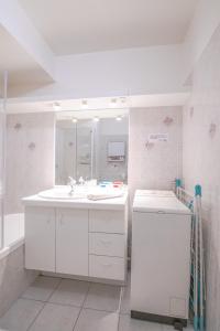 une salle de bains blanche avec un lavabo et un miroir dans l'établissement Le Gouverneur, 100m du lac avec parking, à Annecy 9 autres photos