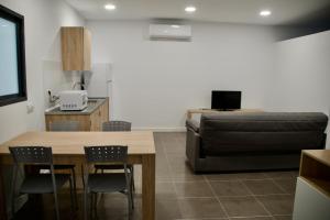 a living room with a couch and a table and chairs at Apartamentos Los Miliarios in Carcaboso