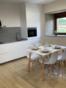 a kitchen with a table and chairs in a room at Eira do Xastre in Brocos +15 photos