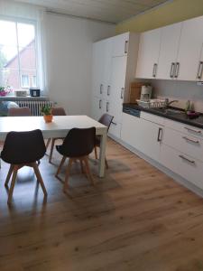 a kitchen with a table and chairs in a room at Ferienwohnung am Drömling Südheide - Kurt in Bergfeld