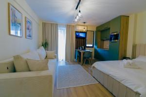 a hotel room with a bed and a couch at Breeze Studios Saturn in Saturn