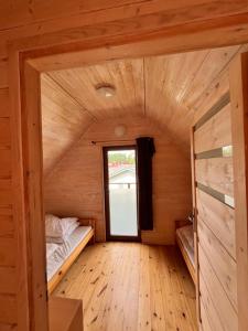 a small room with two beds and a window at Bulisar - Domki Sarbinowo in Sarbinowo