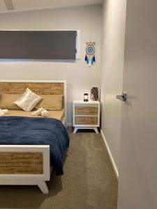 a bedroom with a bed and a clock on the wall at Coastal Hideaway By Lake in Toukley