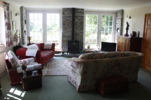 a living room with a couch and a fireplace at Holdstrong Farmhouse in Lydford