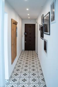 a hallway with a tile floor and a door at Apartament Różowy Jeleń in Gliwice +4 photos