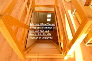 a wooden staircase with a sign on the wall at Lehmhäuschen mit Sauna in Tangermünde