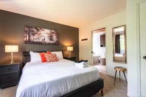 a bedroom with a large bed and a bathroom at Townhouse On The Golf W Pool Access -aiglon 1717 in Mont-Tremblant