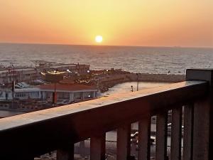a sunset over the ocean from a balcony at شقه مصيفيه للايجار مباشره على البحر في مصطفى كامل الظباط in Alexandria +6 photos