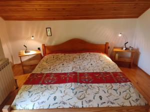 a bed in a bedroom with two lamps on two tables at Villa Beata Apartment 1 upper floor in Kulen Vakuf