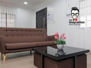 クチンにあるStaycation Homestay 51 Luxe Garden Homestayのソファとコーヒーテーブルのあるリビングルーム