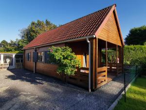 a small wooden cabin with a tree in front of it at Chalet cosy in Condé-Folie