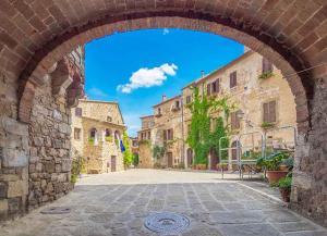 an archway in an alley in an old town at Maremma Toscana Apartment in Manciano
