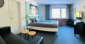 a bedroom with a bed and a couch and a window at Tohuus1875 in Warendorf