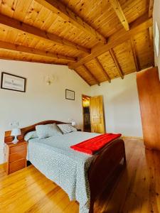 a bedroom with a bed and a wooden ceiling at Casa Nieves Alojamiento Rural in Ampuero