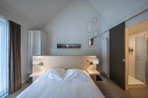 una camera con un letto bianco e una finestra di Antwerp For Two B&B ad Anversa