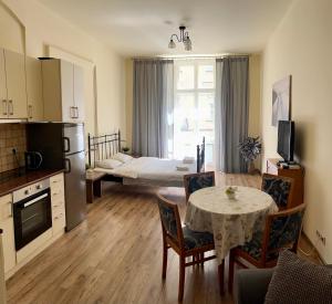 salon ze stołem oraz kuchnia z pokojem w obiekcie Apartamenty i Studia HERBARIUM w Krakowie