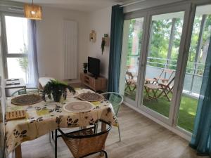 ein Esszimmer mit einem Tisch und Stühlen sowie einem Balkon in der Unterkunft La Nouvelle Vague in Carcans + 1 Foto