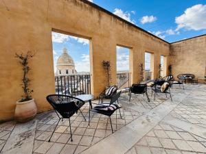 a patio with chairs and tables and a building at Ostello della Gioventù - Il Castello in Noto