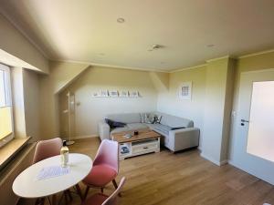 a living room with a table and a couch at Strandliebe Markgrafenheide in Rostock +19 photos