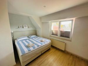 a small bedroom with a bed and a window at Strandliebe Markgrafenheide in Rostock