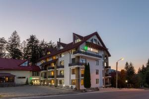 普雷代亚尔赫拉酒店的一座白色的大建筑,有深色的屋顶