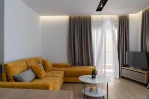 a living room with a couch and a tv at Mateo Apartments in Sarandë