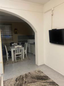sala de estar con mesa con sillas y TV de pantalla plana en Guest House Bajceta, en Herceg-Novi