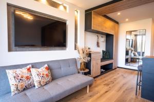 a living room with a couch and a television at Suite Apartment modern getaway - Neu renoviert - Strobl am Wolfgangsee in Strobl