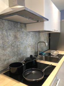 a kitchen with a sink and a stove with pots and pans at Appartamento I Canali in Rio nellʼElba +26 photos