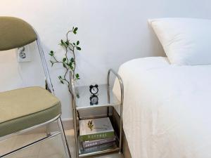 ソウルにあるAnnA Stayのベッドルーム1室(ベッド1台、椅子、本付)