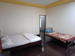 una camera da letto con due letti e uno specchio di Govinda Krishna Comforts a Mysore