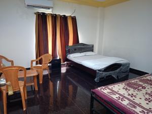 una camera con un letto e una sedia e una finestra di Govinda Krishna Comforts a Mysore Altre 5 foto