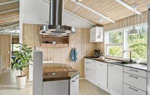 a kitchen with white cabinets and a large window at 4 Bedroom Nice Home In Saltum in Saltum